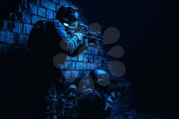 Pair of soldiers in action under cover of darkness low angle