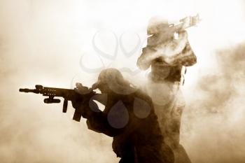 United States Marines in action. Military equipment, army helmet, warpaint, smoked dirty face, tactical gloves. Military action, desert battlefield, smoke grenades