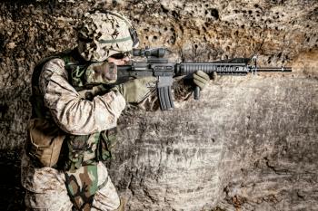 US Marine Corps Soldier in action among the rocks