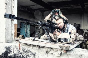 Navy SEAL sniper team, armed 50 caliber sniper rifle, observing territory, waiting in ambush, enemy forces surveillance, searching and engaging targets on range from position in city ruined building