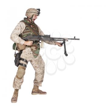 Studio shoot of yelling army soldier with machine gun, Marine Corps machine gunner in camo uniform with ammo belt on body armor, standing, screaming and firing from waist, isolated on white background