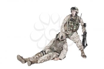 Commando soldier screaming and dragging backwards for plate carrier wounded and unconscious comrade. Tactical combat casualty care, injured combatant evacuating from battlefield, isolated on white