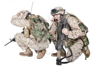 Two soldiers of special forces, marines team crouching to ground and radio communicating with command during battle, calling up reinforcements, reporting situation under enemy fire, isolated on white