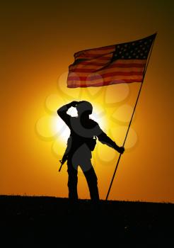 Silhouette of US army soldier, Marines Corps fighter or special forces rifleman in helmet, armed rifle standing on hill with waving on wind national flag, looking far away on background of sunset sky