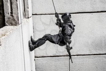 Spec ops police officer SWAT during rope exercises with weapons