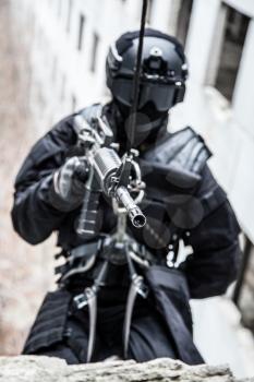 Spec ops police officer SWAT during rope exercises with weapons