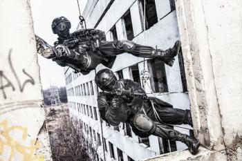 Spec ops police officers SWAT during rope exercises with weapons