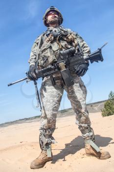 Portrait of United states airborne infantry machinegunner, camo uniforms dress. Combat helmet ammo, low angle view, full body