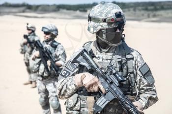 United states airborne infantry men with arms, camo uniforms dress. Front view, two militants are defocus