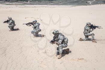 Team of United states airborne infantry men in action in the desert, high angle view