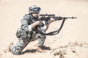 United states airborne infantry marksman in action in the desert, pointing the enemy. High accuracy firing concept
