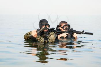 Navy SEAL frogmen with complete diving gear and weapons in the water