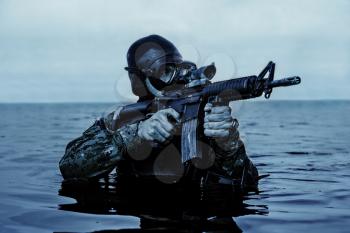 Navy SEAL frogman with complete diving gear and weapons in the water 