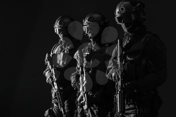 Spec ops police officers SWAT in black uniform and face mask studio shot