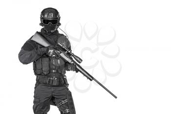 Studio shot of swat operator with sniper rifle wearing black uniforms. Tactical helmet gloves, eyewear and telescopic sight. ecurity forces protecting