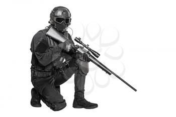 Studio shot of swat operator with sniper rifle wearing black uniforms. Tactical helmet gloves, eyewear and telescopic sight, knee pads