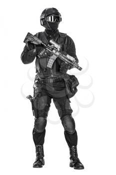 Studio shot of swat operator with assault rifle. Tactical helmet gloves, eyewear. Security forces concept. Full body portrait