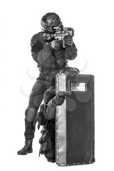 Team of swat police special forces aiming criminals with pistol and rifle hiding behind ballistic shield. Isolated on white full body portait