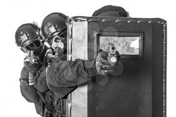 Studio shot of swat police special forces pointing criminals with rifle pistol hiding behind ballistic shield. Isolated on white