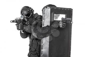 Studio shot of swat police special forces aiming criminals with rifle pistol hiding behind ballistic shield. Isolated on white