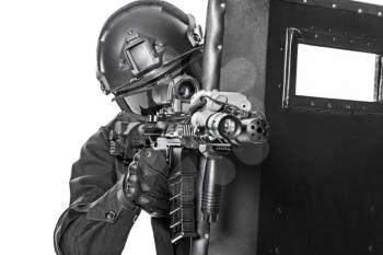 Studio shot of swat police special forces pointing criminals with rifle hiding behind ballistic shield. Isolated on white cropped closeup