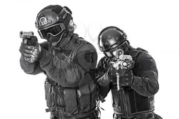 Studio shot of swat police special forces black uniforms aiming terrorists automatic rifle. Tactical helmet vest goggles. Isolated on white side view
