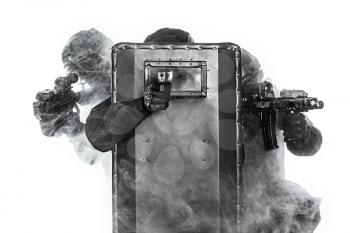 Studio shot of swat police special forces aiming criminals with rifle pistol hiding behind ballistic shield and smokescreen. Isolated on white