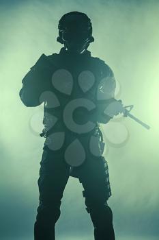 Studio shot of swat police special forces automatic rifle black uniforms. Tactical helmet vest eyewear. Green background