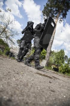 Spec ops police officers SWAT in black uniform in action