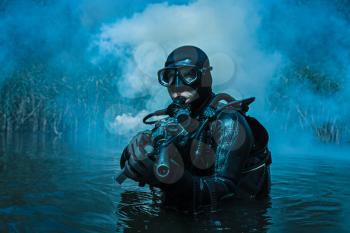 Frogman with complete diving gear and weapons in the water