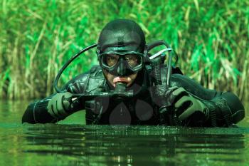Frogman with complete diving gear and weapons in the water