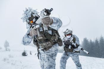 Winter arctic mountains warfare. Action in cold conditions. Pair of special forces weapons in forest somewhere above the Arctic Circle, low angle view