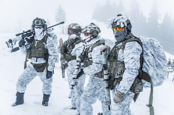 Winter arctic mountains warfare. Action in cold conditions. Squad of soldiers with weapons in forest somewhere above the Arctic Circle