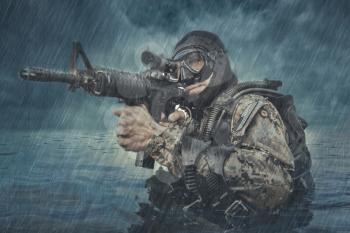Navy SEAL frogman with complete diving gear and weapons in the water 