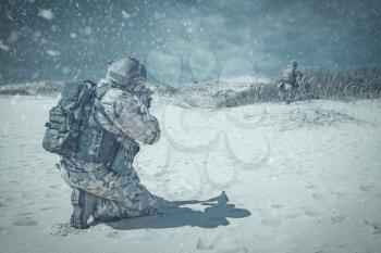 Two soldiers in actiorn through the snowstorm