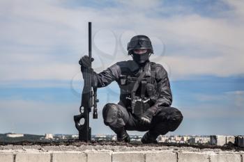 SWAT police sniper in black uniform in action