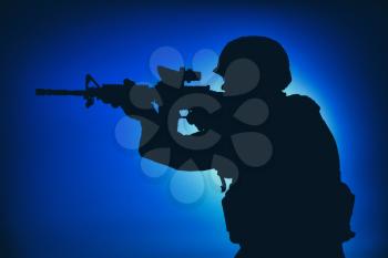 Modern army infantry soldier, coast guard rifleman aiming assault rifle with collimator sight at night. Special operations forces fighter engaging enemy in darkness, observing territory during mission