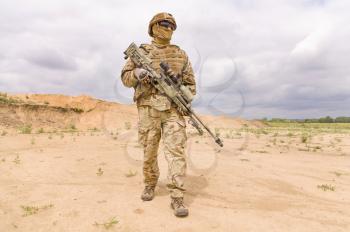 Fully equipped and armed soldier with rifle in the desert. Concept of military anti-terrorism operations, special operations of NATO forces.