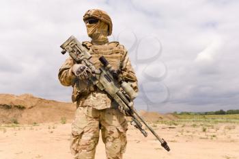 Fully equipped and armed special forces soldier with sniper rifle close-up.