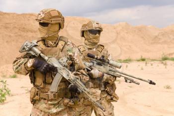 Two equipped and armed special forces soldiers with rifles in the desert