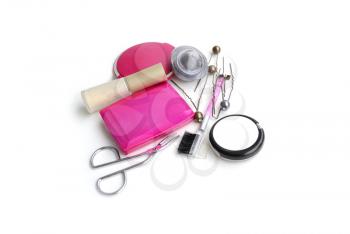 Cosmetics in pink colour, including hairpins and other trifles. On white background.