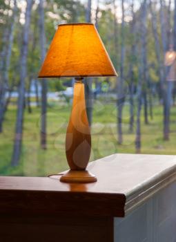 Burning table lamp in front of the window