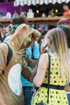 Lviv, Ukraine - August 30, 2015: Guy in a suit deer entertains Woman during the festival of color in a city park in Lviv.
