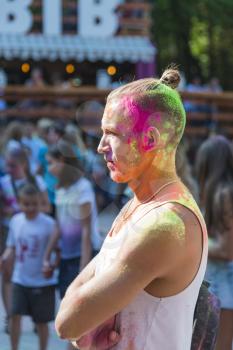 Lviv, Ukraine - August 30, 2015: Man on the head with a tail watches festival of colors in a city park in Lviv.