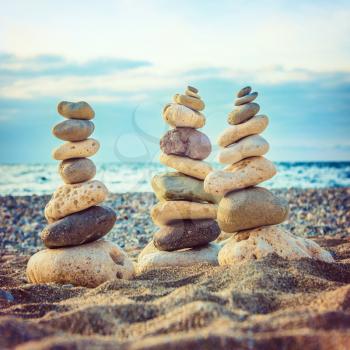 Three stacks of round smooth stones on the beach