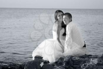 Beautiful wedding couple- bride and groom hugging at the beach. Just married. Black and white, sepia