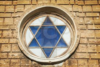 Blue star of David in the window. Yellow wall at background 