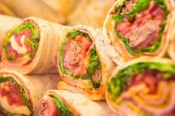 Fresh tortilla wraps with vegetables. Many rolls as background