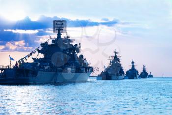 Row of military ships against marine sunset