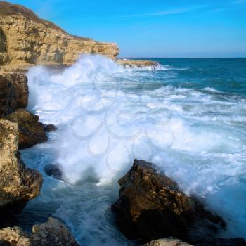 Big waves breaking on the shore with sea foam